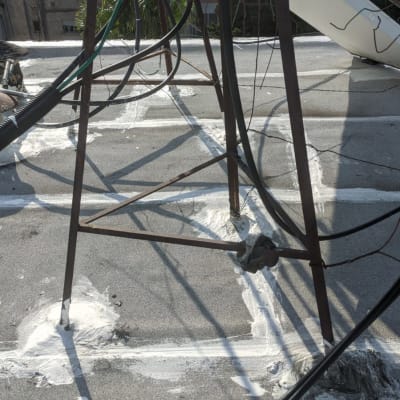 איטום גג עם חומר לבן סביב עמודי מתכת