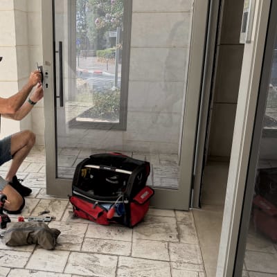 אדם עובד על דלת עם כלי עבודה