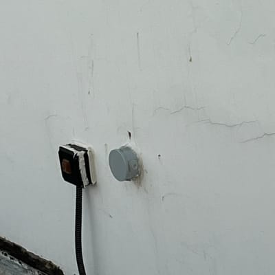 שקע חשמלי על קיר עם חוטים חשופים