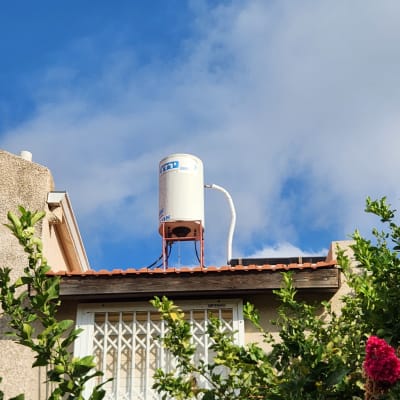 דוד שמש על גג עם צינור לבן