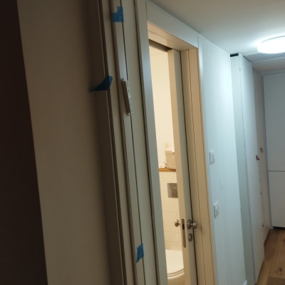 דלת לבנה עם ידיות מתכת וסרטי הדבקה כחולים