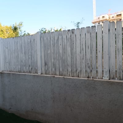 גדר עץ לבנה על קיר בטון