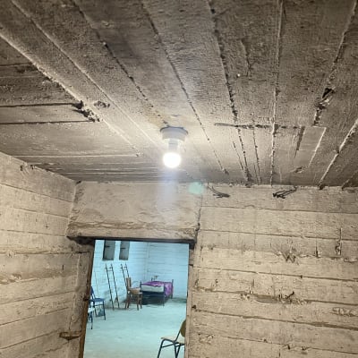 נורה חשמלית תלויה מהתקרה בחדר בטון