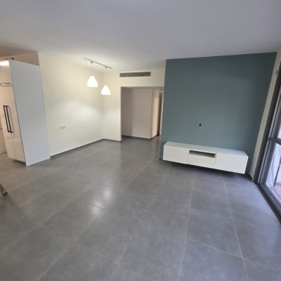 חדר עם קיר צבוע בצבע כחול ורצפת אריחים אפורה