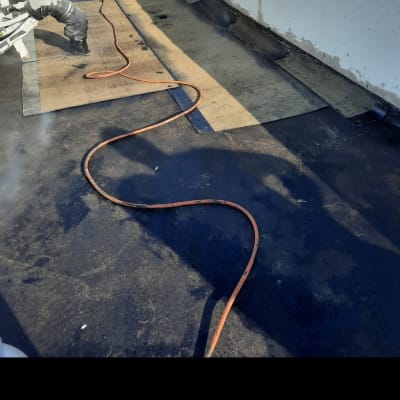 עבודת איטום גג עם יריעות ביטומניות וצינור גז