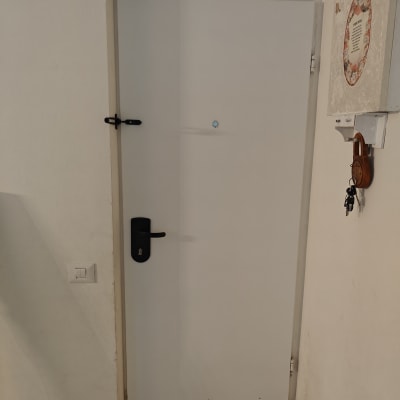 דלת לבנה עם ידית ומנעול שחורים