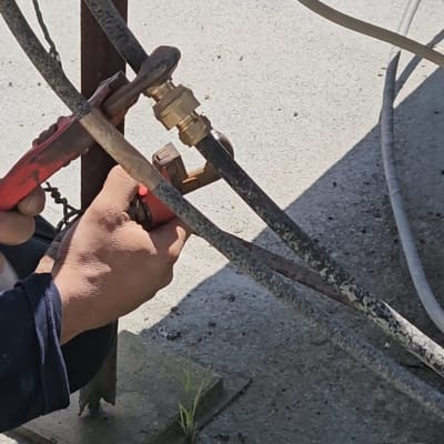 ידיים מחזיקות כלי עבודה על צינור דוד שמש