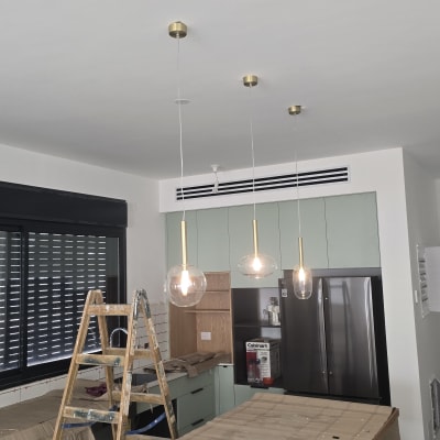 סולם עץ ליד מנורות תלויות בתהליך התקנה