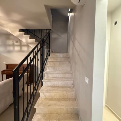 מדרגות עם מעקה מתכת וקיר צבוע