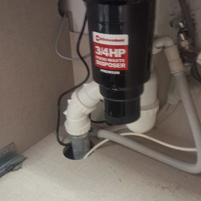 מטחנת אשפה מתחת לכיור עם צינורות חיבור