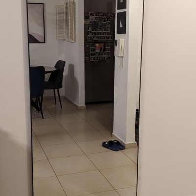 מראה גדולה תלויה על קיר לבן