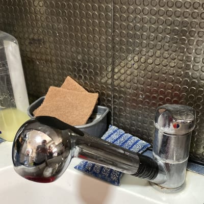 ברז מטבח עם ידית מתכת מבריקה וספוגים