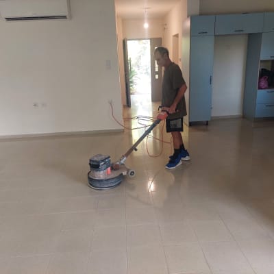 אדם מנקה רצפה עם מכונת פוליש חשמלית