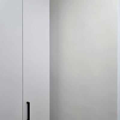 קיר צבוע ליד ארון לבן עם ידית שחורה