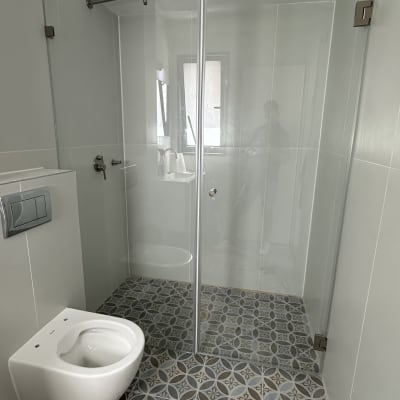 מקלחון זכוכית עם דלתות הזזה ומוט מתכת