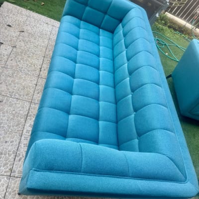 ספה כחולה בחוץ על מרפסת מרוצפת