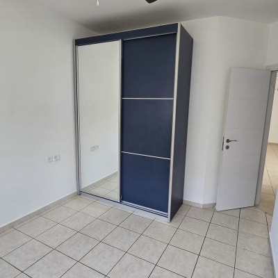 חדר ריק עם מאוורר תקרה וארון בגדים