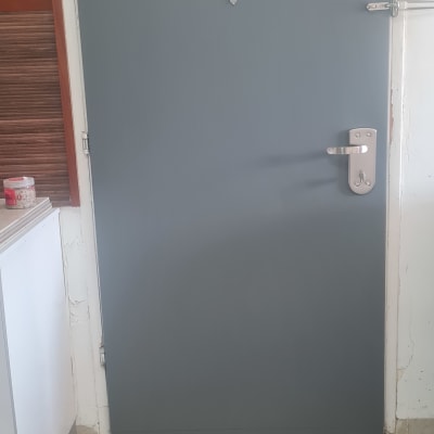 דלת מצופה בצבע אפור עם ידית כסופה