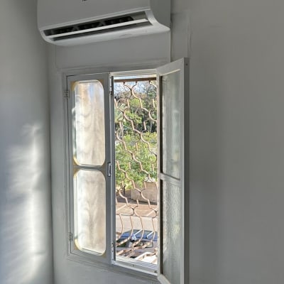 מזגן מותקן על קיר מעל חלון פתוח