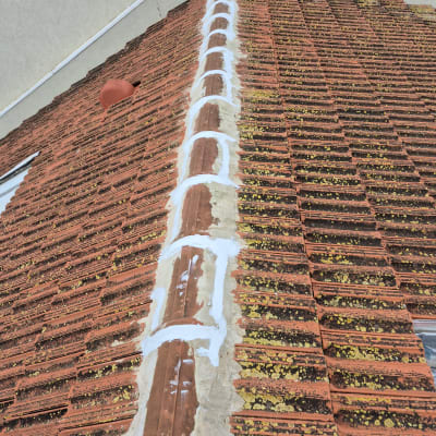 גג רעפים עם תיקוני איטום לבנים