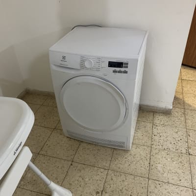 מייבש כביסה לבן על רצפת אריחים