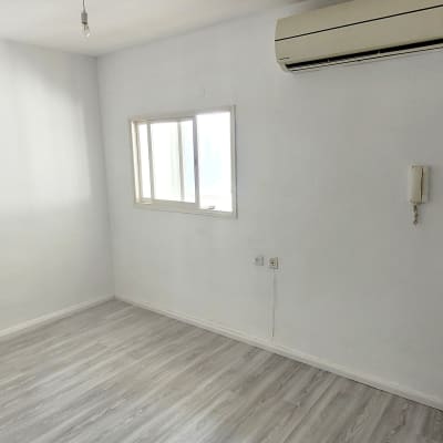 חדר ריק עם מזגן, חלון ודלת למטבח