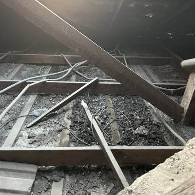 תמונה של גג עם קורות עץ וחוטים חשמליים