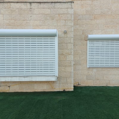 תריסי אלומיניום סגורים על קיר אבן חיצוני