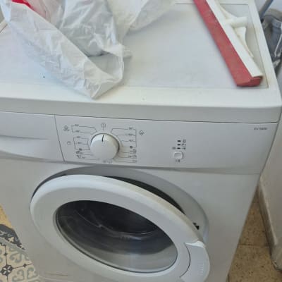 מכונת כביסה עם שקית פלסטיק ומגב על הרצפה