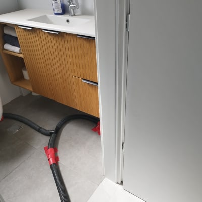 צינור ייבוש מחובר לרצפה ליד כיור בחדר אמבטיה