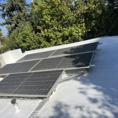 גג אטום עם לוחות סולאריים וציפוי לבן