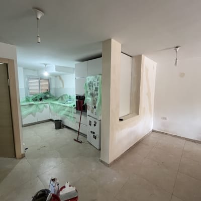 חדר עם קירות צבועים וכלי צביעה על הרצפה