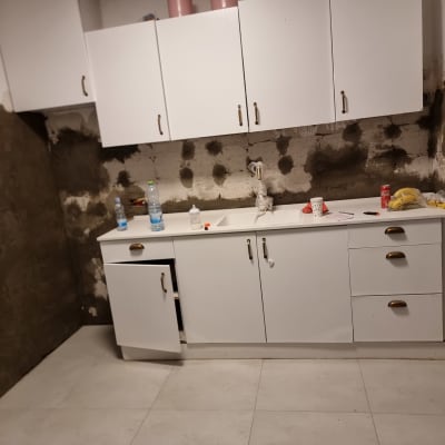 מטבח בשיפוץ עם קירות חשופים וארונות מותקנים