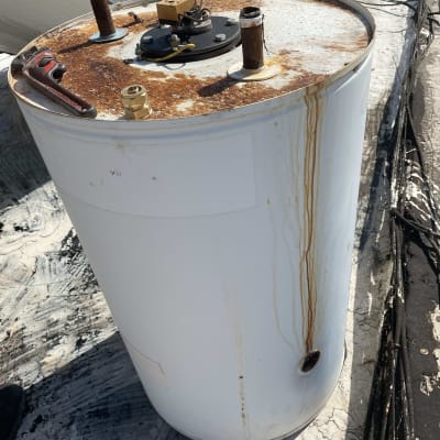 דוד שמש עם חלודה על הגג, צינורות וחיבורים גלויים