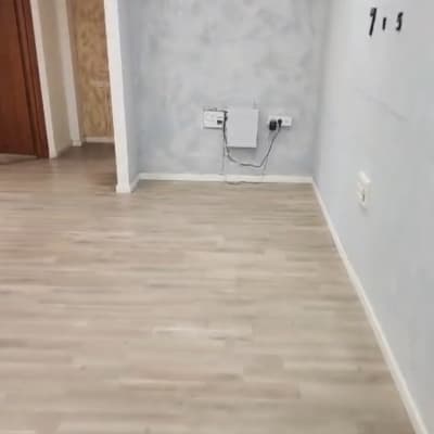 רצפת עץ עם קיר אפור ושעון קיר