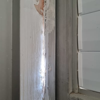 קיר מתקלף עם סימני תיקון ושכבת צבע חדשה