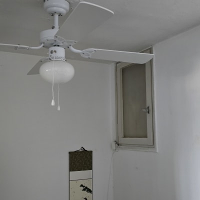 מאוורר תקרה עם מנורה תלויה בחדר