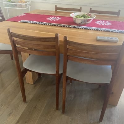 כיסאות עץ עם ריפוד אפור סביב שולחן עץ