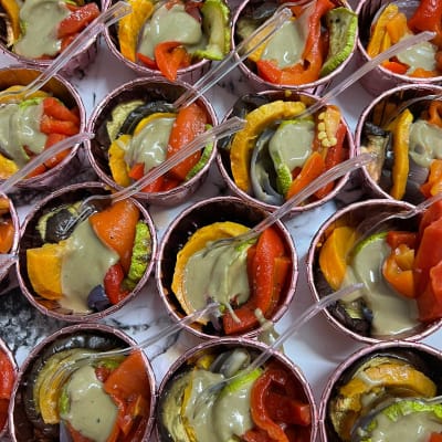 מנות קטנות של ירקות קלויים עם רוטב בכלי הגשה אישיים