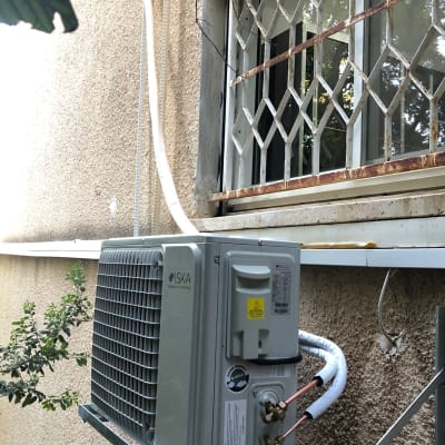יחידת מזגן חיצונית מותקנת על קיר עם צינורות