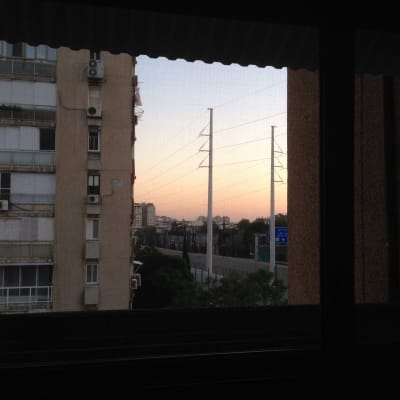 חלון אלומיניום עם נוף עירוני ברקע