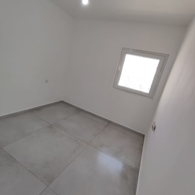 חדר ריק עם רצפת אריחים ולבן קירות