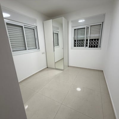 חדר ריק עם חלונות וארון מראה