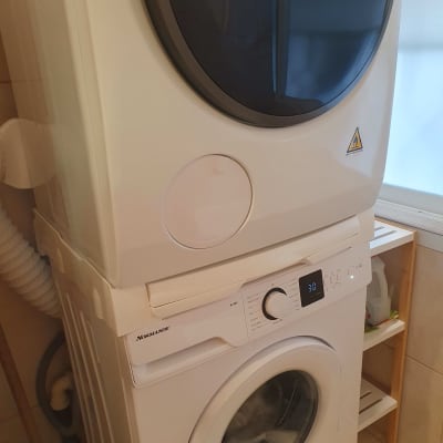 מכונת כביסה ומייבש כביסה מוערמים בחדר כביסה