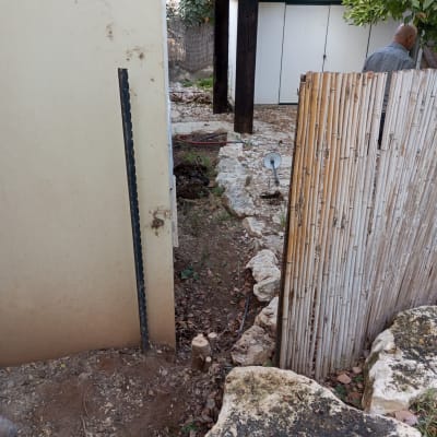 קיר עם מוט מתכת לאיטום חיצוני בגינה