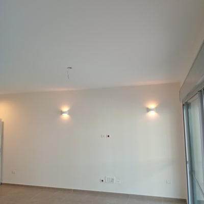 קיר צבוע בלבן עם תאורה עליונה