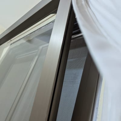 חלון פתוח עם מסגרת מתכת ווילון לבן