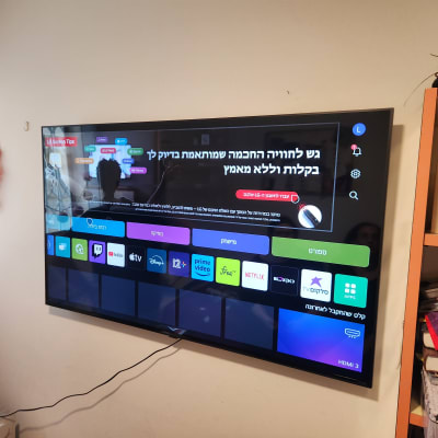 טלוויזיה מותקנת על קיר עם תפריט אפליקציות