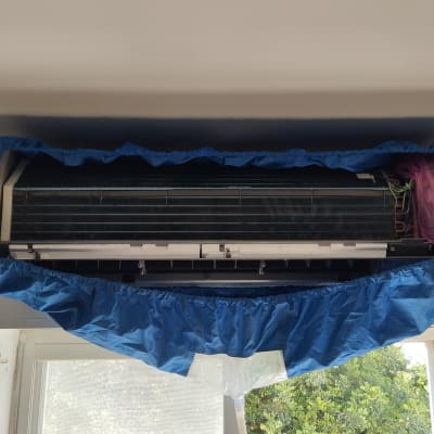 מזגן עם כיסוי כחול לניקוי ותחזוקה