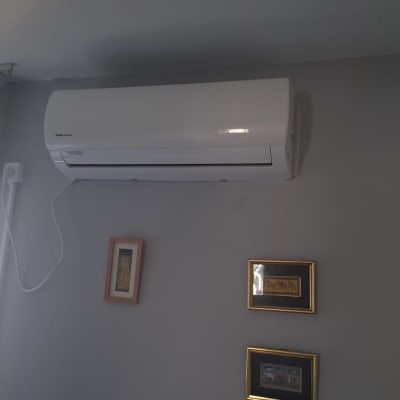 מזגן מותקן על קיר עם תמונות ממוסגרות